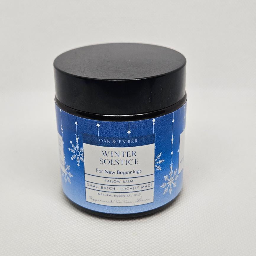 Jar of 'Winter Solstice' balm with blue label on a light gray background