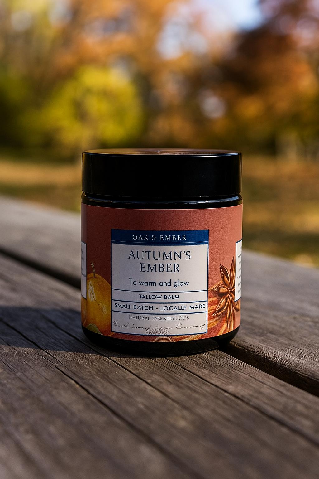 Jar of 'Autumn's Ember' balm on a wooden surface with a blurred natural background