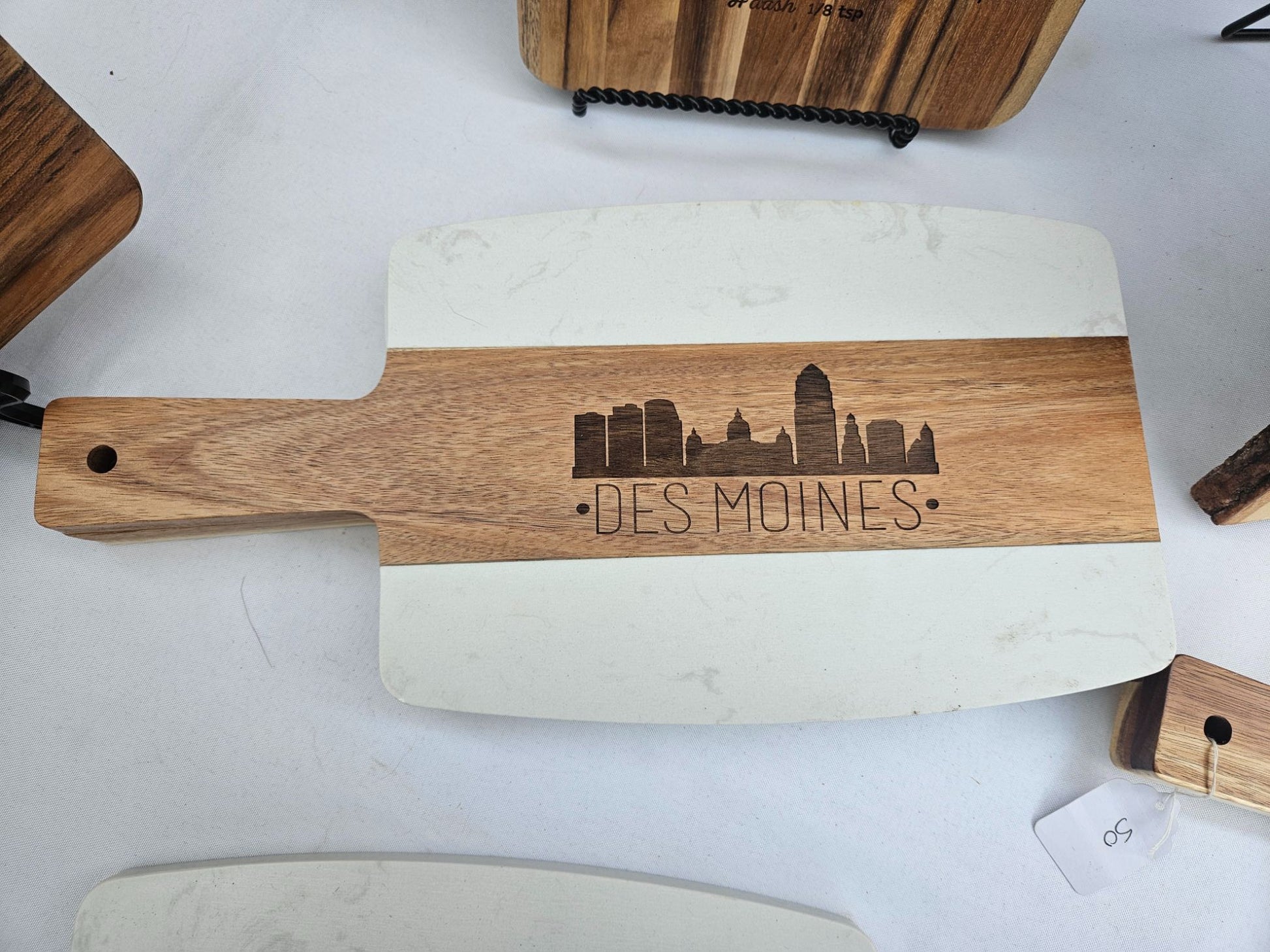 Wooden cutting board with engraved 'Des Moines' design on a white surface