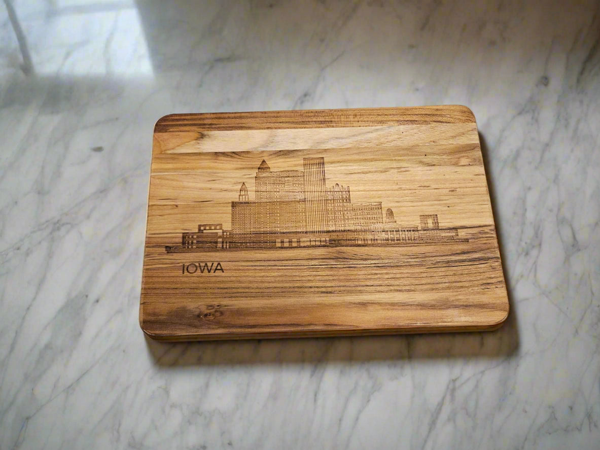 Wooden cutting board with 'Iowa' engraving on a patterned fabric background