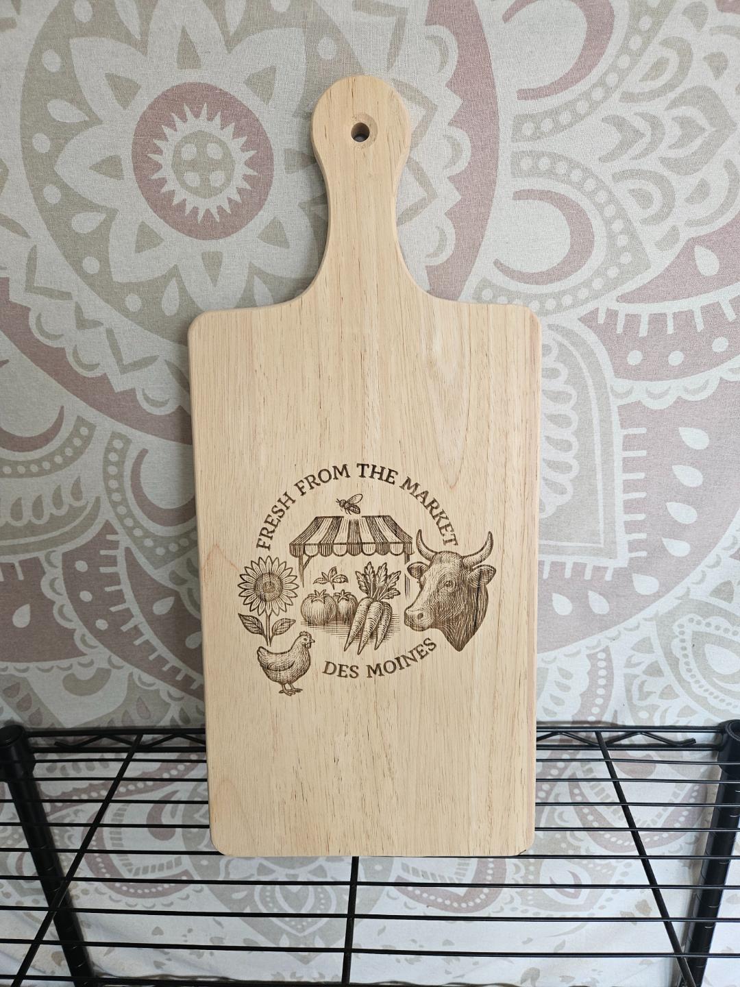 Wooden cutting board with engraved design on a patterned wall background