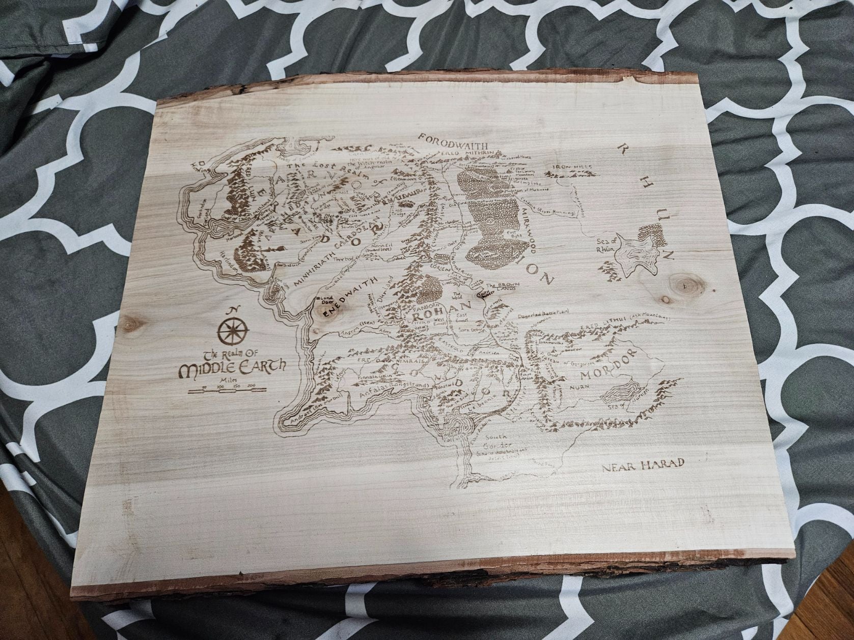 Wooden map of Middle-earth on a patterned fabric background