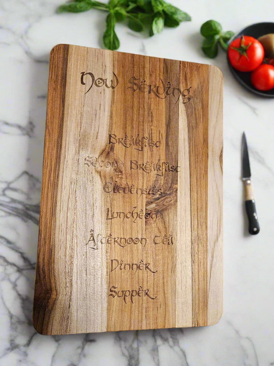Wooden cutting board with engraved text on a patterned fabric background