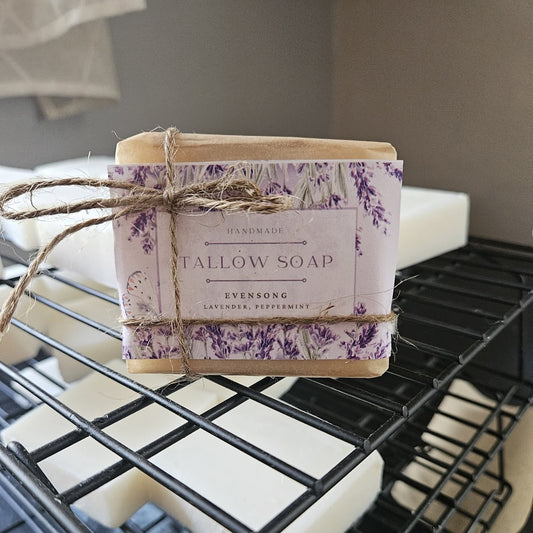 Handmade tallow soap with a decorative label on a black metal rack.