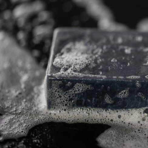 Bar of soap with lather on a dark background